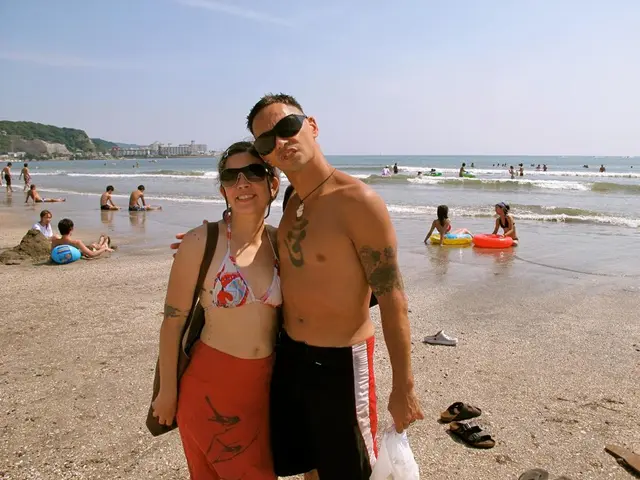 In this image I can see a beach area where there are people who are diving in water and playing...