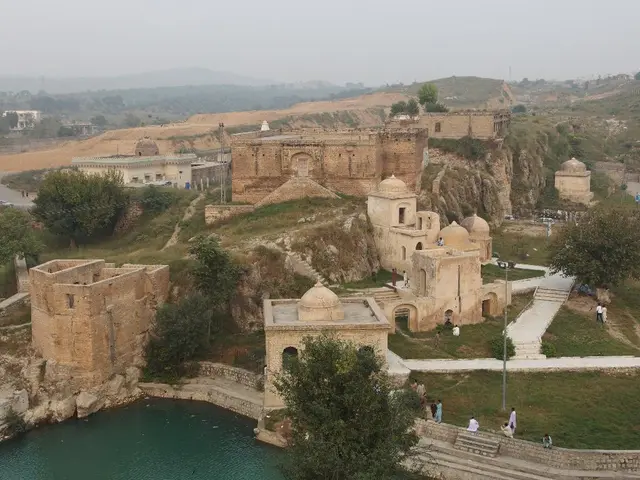 In the image there are many castles and buildings on the land with grass all around the place along...